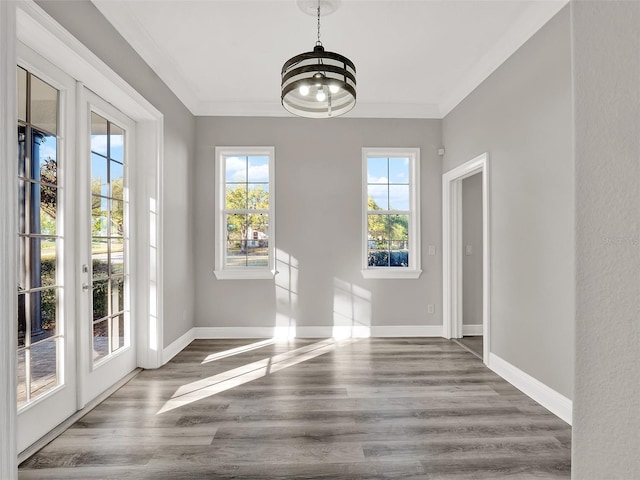 7548 Gathering Dr, Reunion, FL 34747 - unfurnished dining area featuring wood finished floors, baseboards, ornamental molding, french doors, and a notable chandelier
