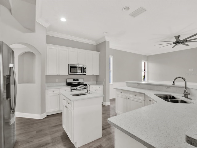 7548 Gathering Dr, Reunion, FL 34747 - kitchen featuring visible vents, a center island with sink, ornamental molding, stainless steel appliances, and a sink