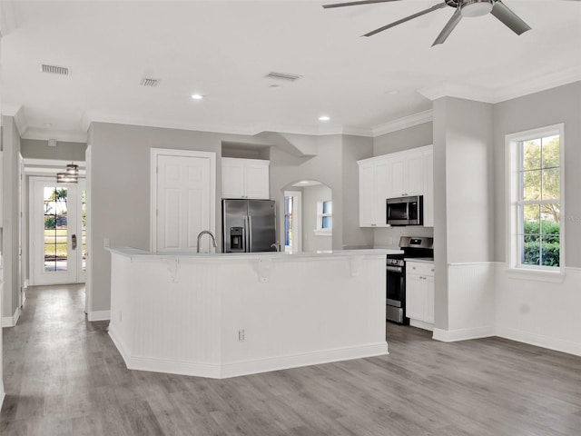 7548 Gathering Dr, Reunion, FL 34747 - kitchen featuring a breakfast bar area, a healthy amount of sunlight, visible vents, and appliances with stainless steel finishes