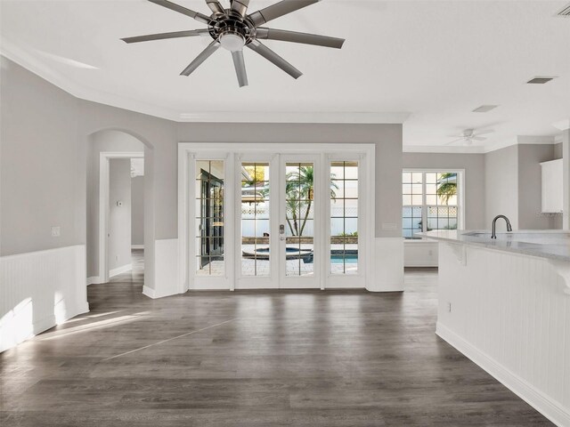 7548 Gathering Dr, Reunion, FL 34747 - interior space featuring a ceiling fan, arched walkways, dark wood-style flooring, ornamental molding, and french doors