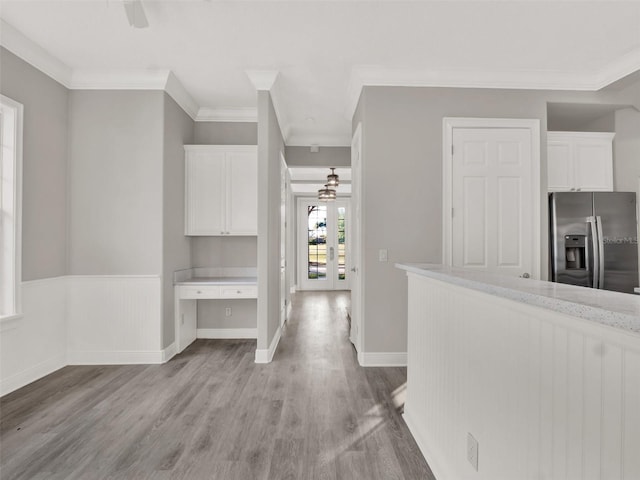 7548 Gathering Dr, Reunion, FL 34747 - hallway featuring crown molding, light wood-style floors, baseboards, and wainscoting