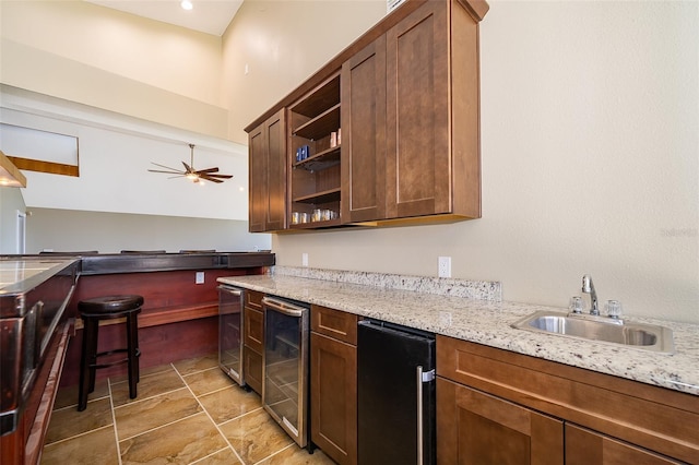 kitchen with wine cooler, open shelves, light stone countertops, and a sink