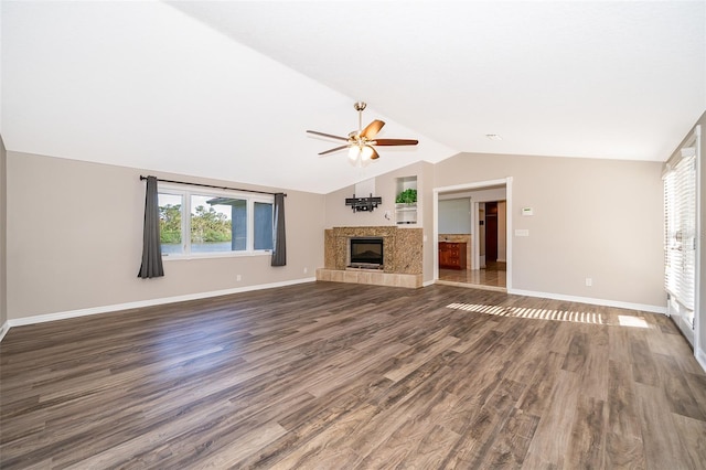 unfurnished living room featuring lofted ceiling, a ceiling fan, wood finished floors, baseboards, and a tile fireplace