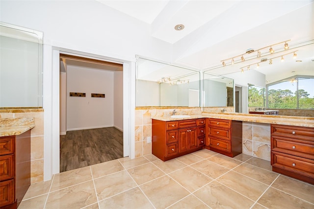 bathroom featuring double vanity, tile patterned flooring, tile walls, and a sink