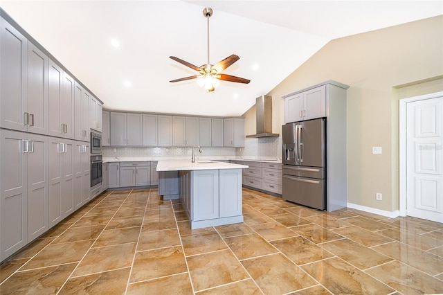 kitchen with gray cabinets, stainless steel appliances, light countertops, and wall chimney range hood