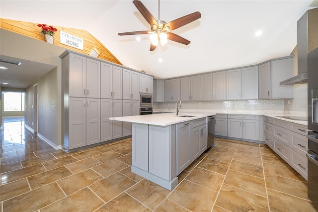 kitchen with gray cabinetry, a sink, tasteful backsplash, stainless steel appliances, and vaulted ceiling