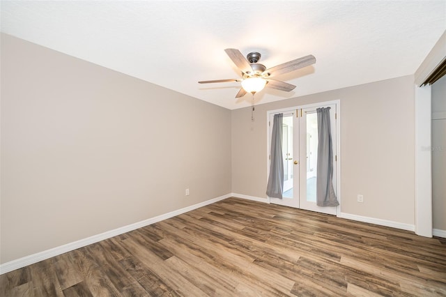 empty room featuring a ceiling fan, wood finished floors, baseboards, and french doors