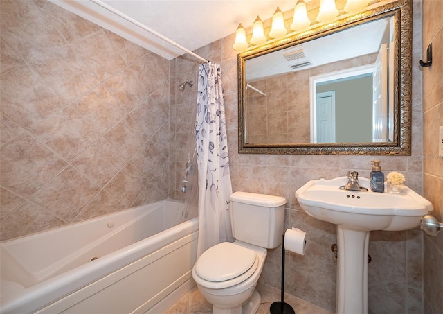 bathroom featuring tile walls, visible vents, toilet, and shower / tub combo with curtain