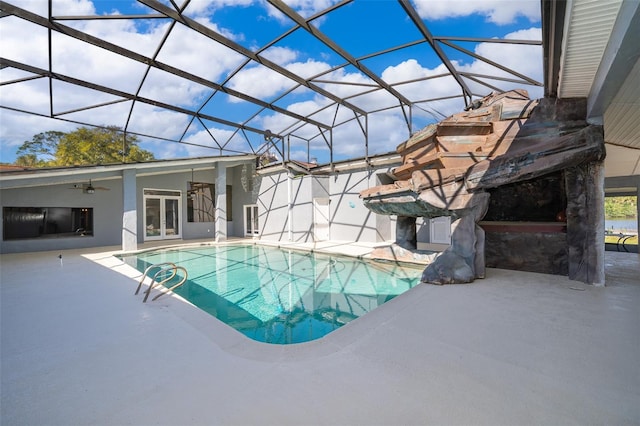 view of swimming pool featuring glass enclosure, french doors, a patio, and ceiling fan