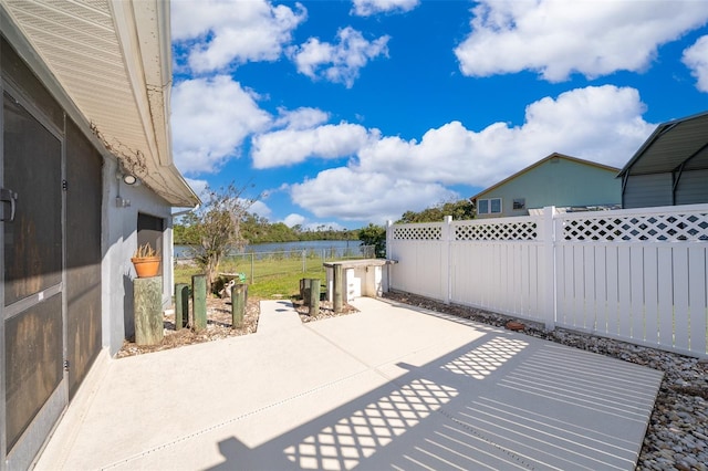 view of patio with a water view and a fenced backyard