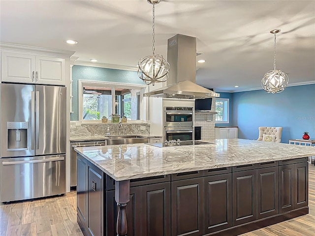 kitchen with light wood-type flooring, island exhaust hood, a sink, stainless steel appliances, and white cabinets