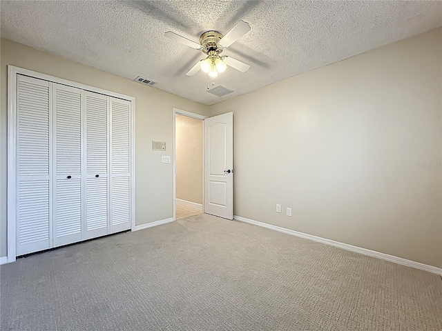 unfurnished bedroom with visible vents, light carpet, a textured ceiling, a closet, and baseboards