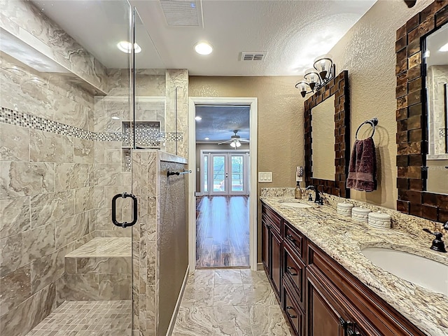 bathroom featuring visible vents, a textured wall, and a sink