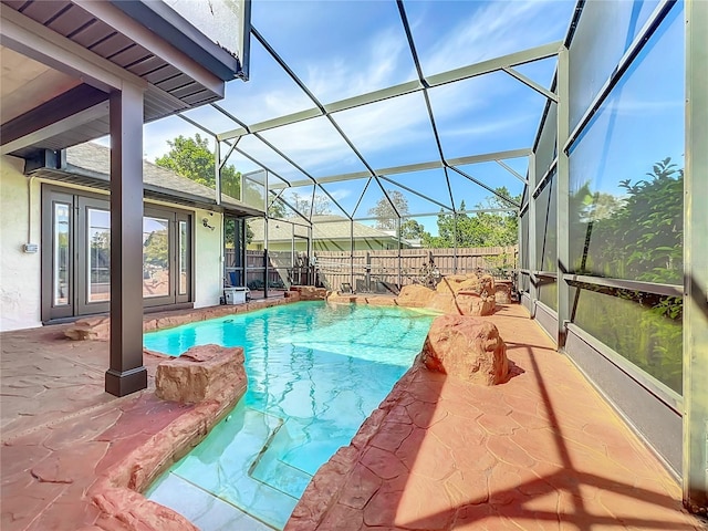 view of swimming pool with glass enclosure, a patio area, a fenced backyard, and a fenced in pool