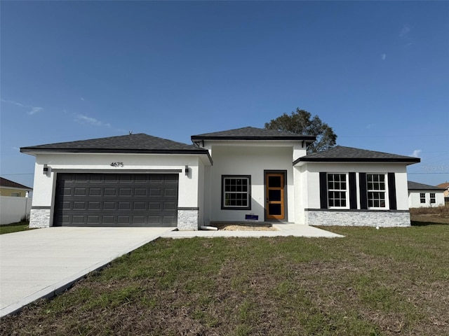 prairie-style home featuring stone siding, a front lawn, and an attached garage