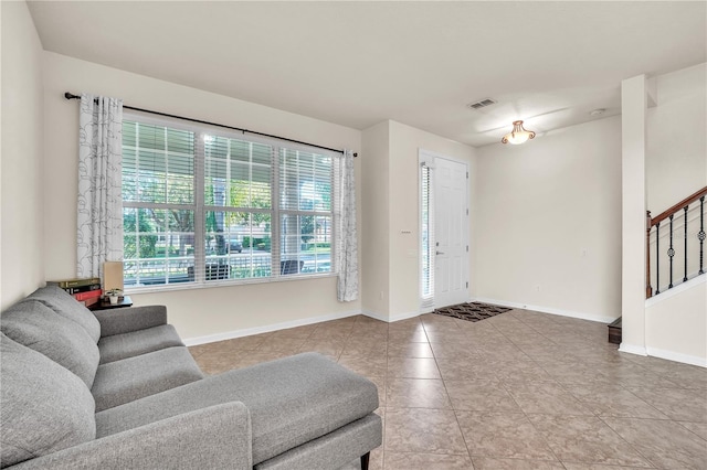 foyer featuring tile patterned floors, visible vents, stairs, and baseboards