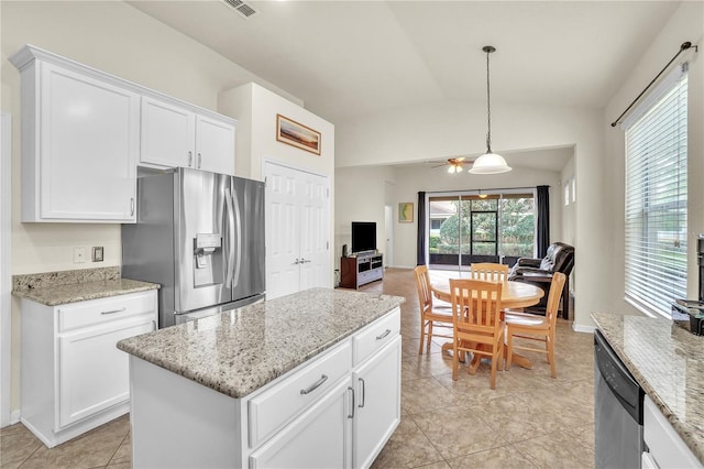 kitchen featuring open floor plan, lofted ceiling, stainless steel appliances, hanging light fixtures, and white cabinetry