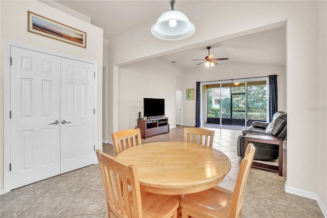 dining space featuring light tile patterned floors, baseboards, a ceiling fan, and lofted ceiling