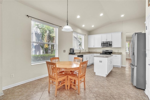 kitchen with a center island, stainless steel appliances, baseboards, white cabinets, and lofted ceiling