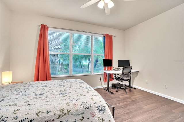 bedroom featuring a ceiling fan, wood finished floors, and baseboards