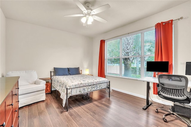 bedroom featuring ceiling fan, baseboards, and wood finished floors