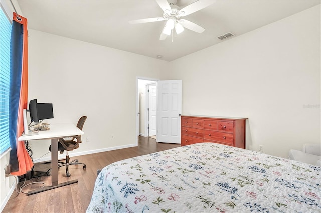 bedroom featuring ceiling fan, wood finished floors, visible vents, and baseboards