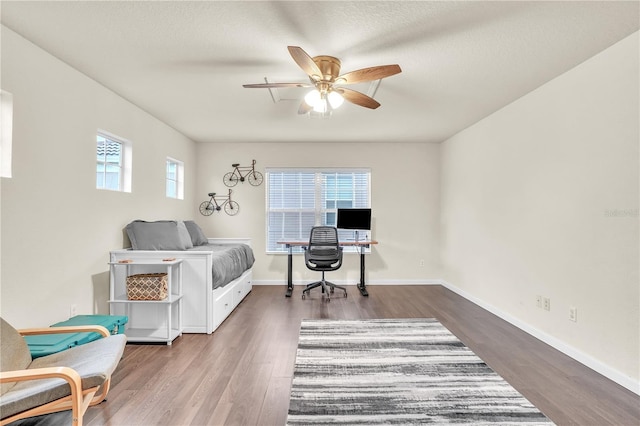 bedroom featuring ceiling fan, baseboards, and wood finished floors