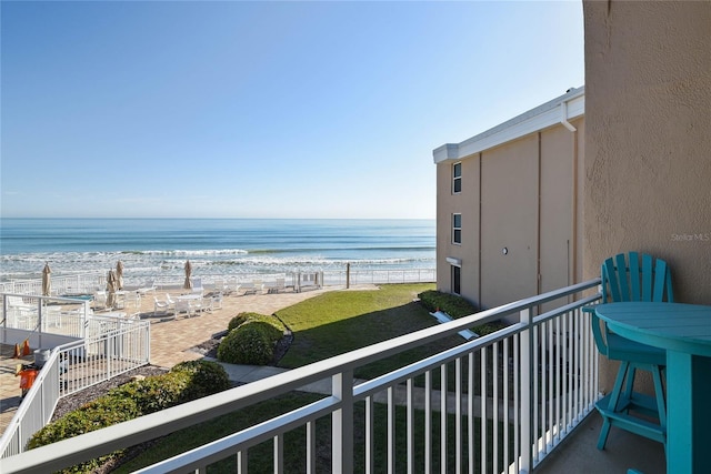 balcony featuring a beach view and a water view