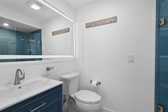 bathroom featuring a shower stall, toilet, and vanity