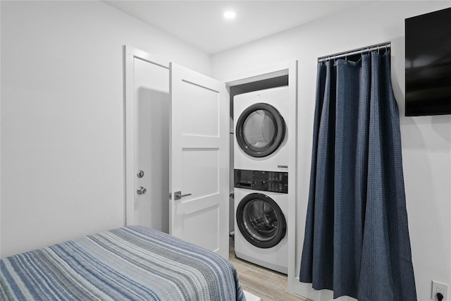 bedroom featuring light wood finished floors, recessed lighting, and stacked washer / drying machine