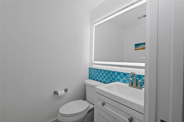 bathroom with visible vents, toilet, and vanity