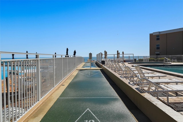 view of community featuring shuffleboard and fence