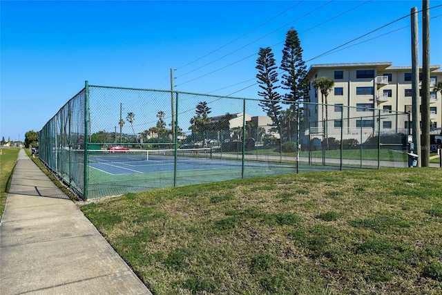 view of sport court featuring a lawn and fence