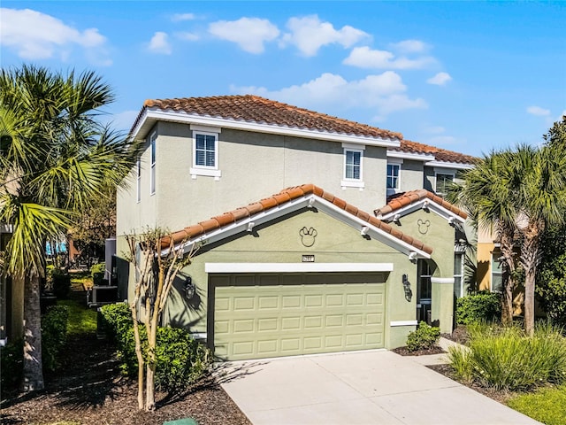 mediterranean / spanish house featuring stucco siding, an attached garage, driveway, and a tiled roof