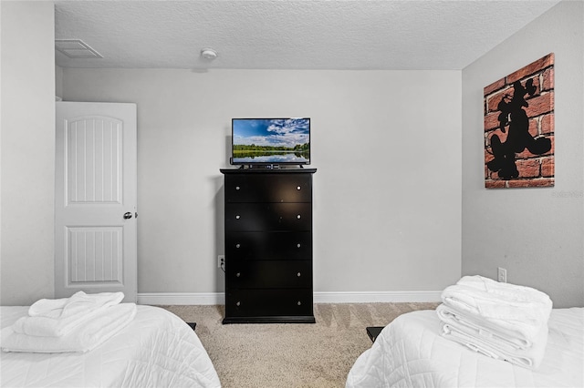 bedroom with visible vents, baseboards, carpet floors, and a textured ceiling