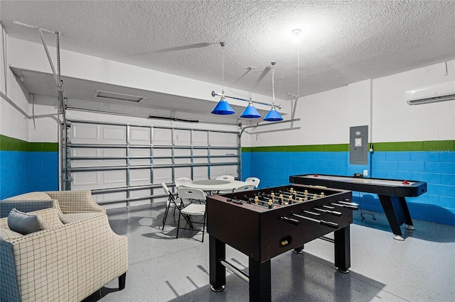 recreation room with electric panel, speckled floor, a garage, and a wall unit AC