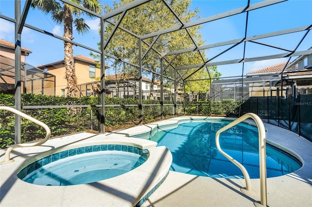 view of pool with glass enclosure, a patio area, and a pool with connected hot tub