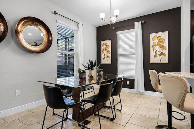 dining space with a notable chandelier, light tile patterned floors, and baseboards