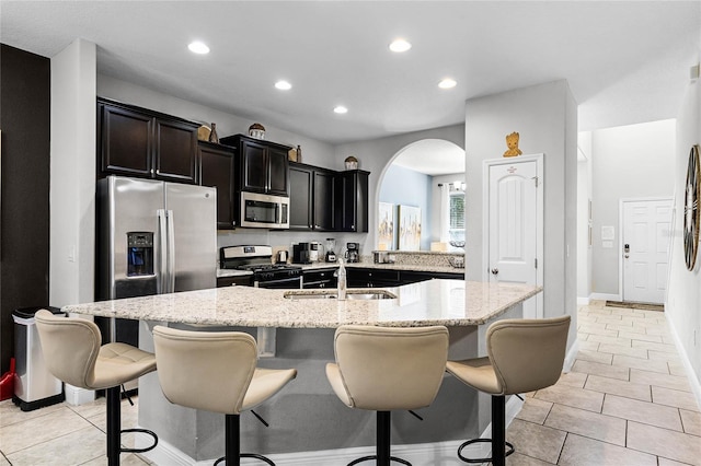 kitchen featuring a sink, a breakfast bar, an island with sink, and stainless steel appliances