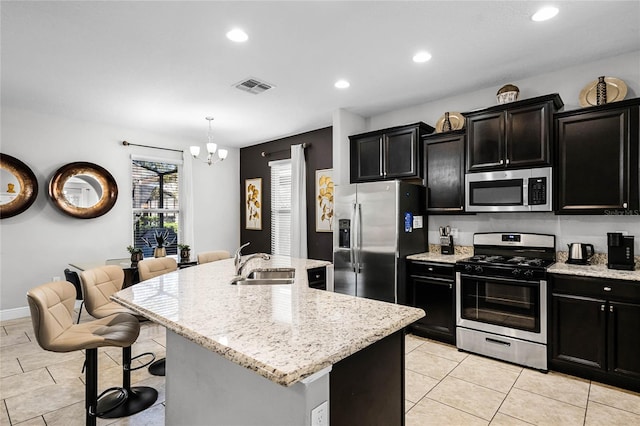 kitchen featuring dark cabinetry, visible vents, appliances with stainless steel finishes, and a sink