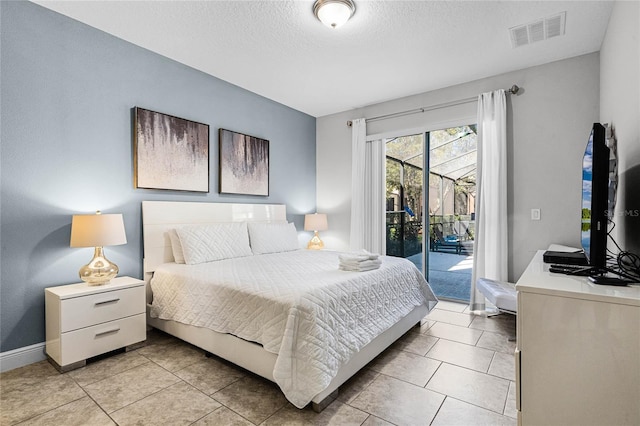 bedroom featuring light tile patterned floors, visible vents, a textured ceiling, and access to outside