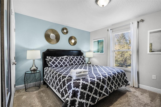 carpeted bedroom featuring a textured ceiling and baseboards