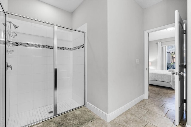 ensuite bathroom featuring a shower stall, baseboards, and ensuite bathroom