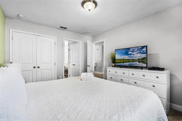 bedroom with baseboards, visible vents, a closet, and a textured ceiling