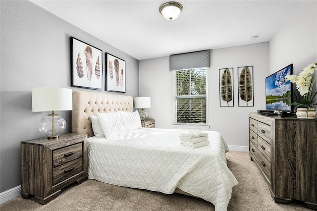 bedroom featuring baseboards and light carpet