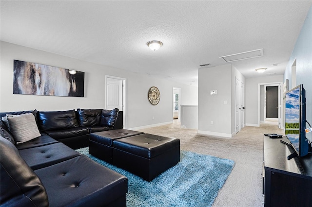 living area featuring visible vents, baseboards, attic access, a textured ceiling, and light colored carpet