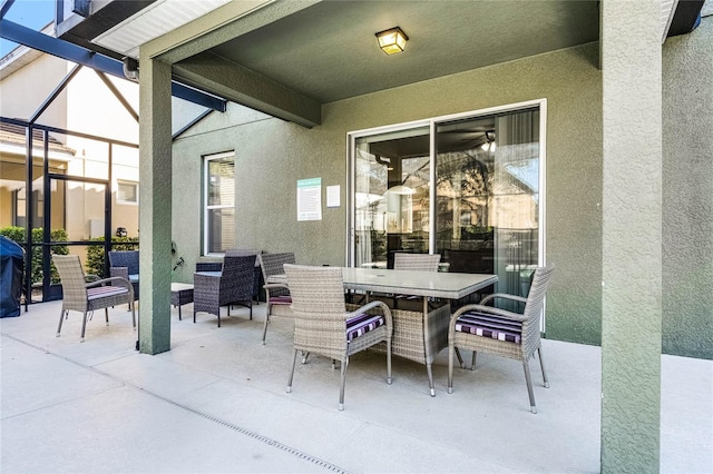 view of patio with outdoor dining space and glass enclosure