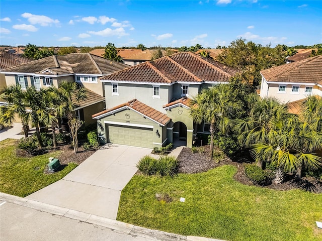 mediterranean / spanish-style house with stucco siding, driveway, a front yard, an attached garage, and a tiled roof