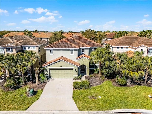 mediterranean / spanish house with stucco siding, a tile roof, concrete driveway, a front yard, and an attached garage