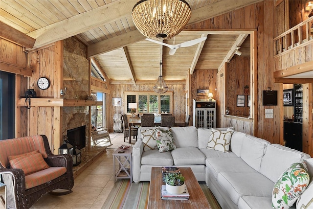 living area with a chandelier, wood walls, a fireplace, and wood ceiling